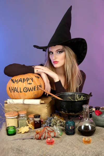 Хэллоуин ведьмы готовит яд суп в ее котел на цвет фона — стоковое фото