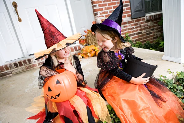 Хэллоуин: девушки сидят на крыльце с трюк или лечения конфеты — стоковое фото