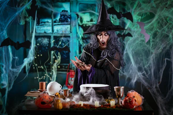 Ведьма готовит волшебного зелья с костями — стоковое фото